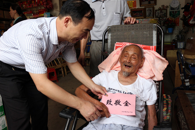 赖小景副校长为黄胜庸老战士送上致敬金