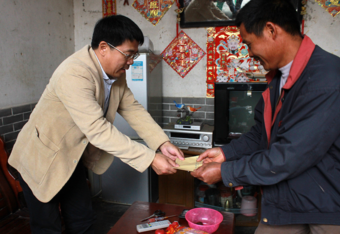 刘安华校长为村民送上慰问金