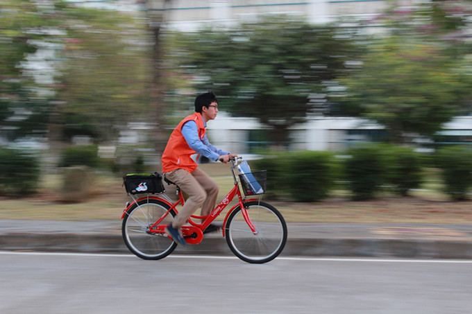 “马上办”工作人员骑着自行车穿梭在校园中